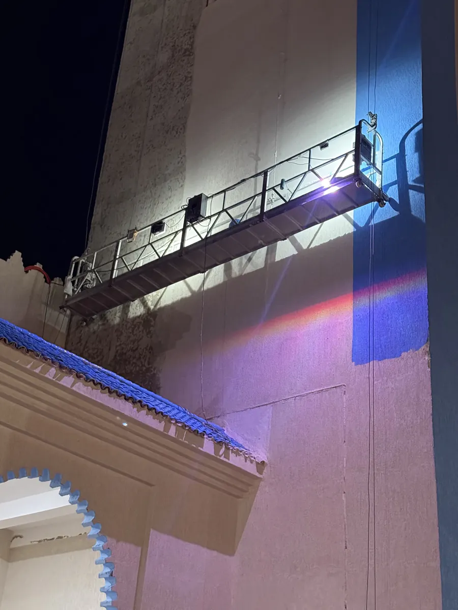Nacelle suspendue en travail de nuit le long d'une façade
